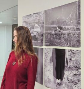 a woman looking at a wall with pictures on it